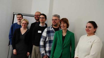 Ein in den R&auml;umen der Aidshilfe Wiesbaden aufgenommenes Gruppenfoto von sieben Personen, unter ihnen Staatssekret&auml;rin Eichner und Ministerin Hofmann.