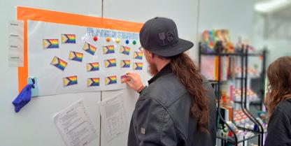 Mit einem Flaggenmemory konnten sich Besucher*innen über die Vielfalt queerer Lebensweisen informieren. Ein Besucher des Infostands beschäftigt sich mit dem "Flaggen-Memory".